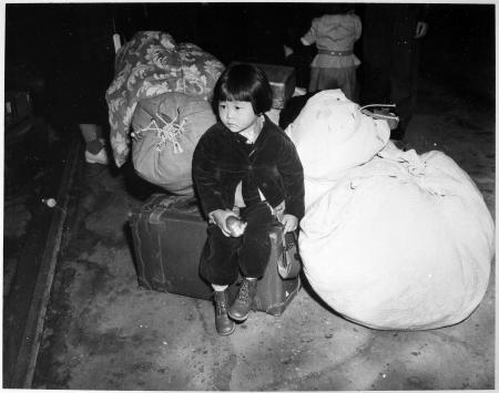 2020年7月21日に米国国立公文書館から入手したこの1942年の写真には、ロサンゼルスの駅でスーツケースの上に一人で座っている2歳のユキ・オキナガ・ハヤカワの姿が写っている(AFP)