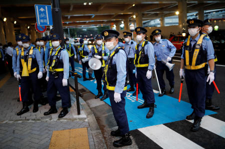 東京の国立競技場近くで金曜に行われた東京2020オリンピックに反対するデモ中に見られた警察官たちの姿。(ロイター)