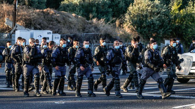 2020年7月1日、イスラエル北部のワディアラ地区にあるアラブの町アララで、ヨルダン川西岸の一部を併合するというイスラエルの計画に抗議するデモの参加者が集まり、イスラエルの警官が待機している。（AFP通信）