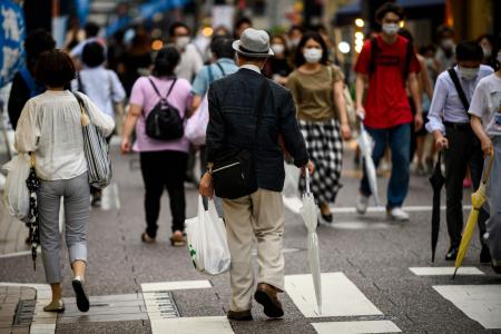 2020年7月1日、東京で買い物品をビニール袋に入れて運ぶ男性。(AFP)