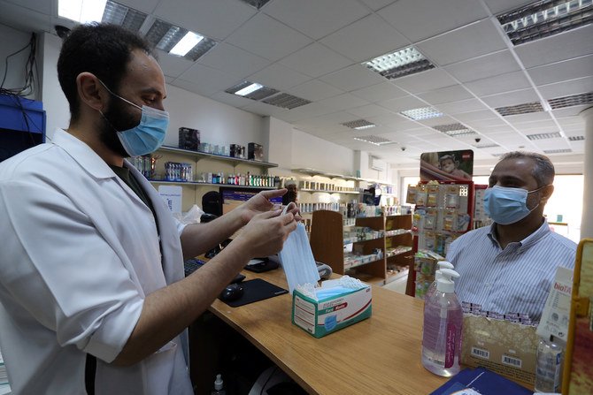 2020年7月5日、サウジアラビアのリヤドで、政府がコロナウイルス感染症（COVID-19）の封鎖制限を解除した後、防護マスクを着用した男性が薬局からマスクを購入する。（ロイター）