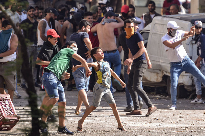 2020年6月13日、北部の港町トリポリのバブ・アルタバベナ地区で、レバノンの反政府抗議者たちが衝突した兵士たちに石を投げつけている。（AFP資料写真）