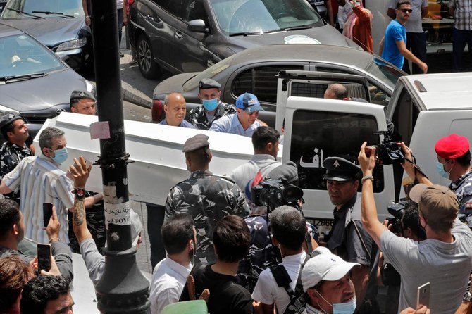自殺した男性の棺を救急車に運び入れる救急隊員。首都ベイルートのハムラ通りで、2020年7月3日に撮影。（AFP）