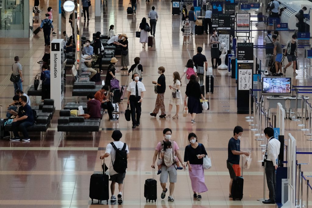 2020年7月25日、東京の羽田空港国内線出発ロビーで、人々がマスクを着けているようすが見受けられる。（AFP通信）