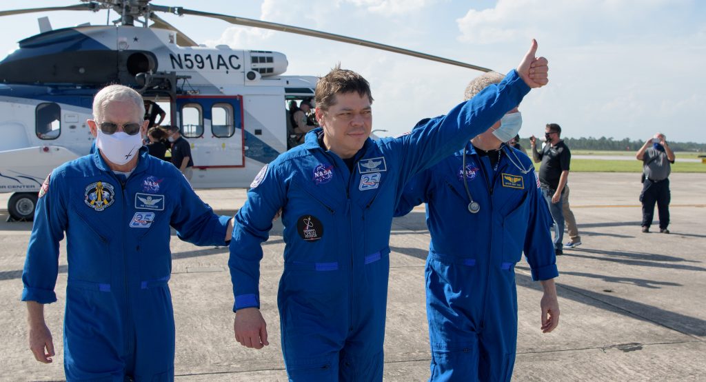 2020年8月2日、スペースXのクルードラゴン「エンデバー号」宇宙船がフロリダ州ペンサコーラ沖に着水した数時間後、NASA宇宙飛行士ダグラス・ハーリーとともにヒューストンへと帰る飛行機に搭乗する際、見物人に対して親指を立てるNASA宇宙飛行士ロバート・ベンケン。NASA/ビル・インガルス/ロイター経由の配布資料