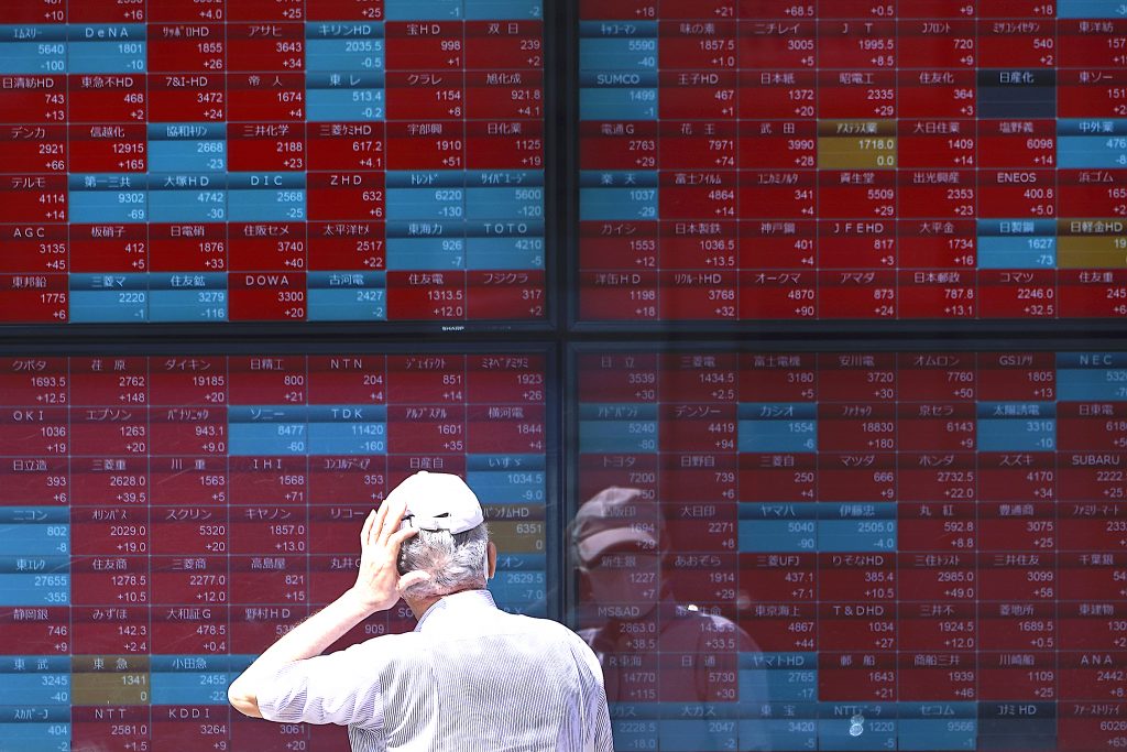 2020年8月12日、東京の証券会社で日経225指数を表示する電子株価掲示板を見る男性(File photo / AP)