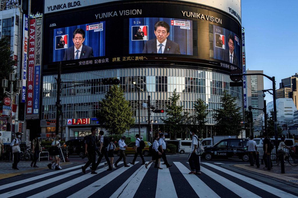 2020年8月28日東京でのライブ記者会見で大画面に映る日本の安倍晋三首相(AFP)