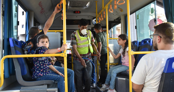 シリア北東部の都市アレッポでバスを消毒する地方自治体職員。（AFP）