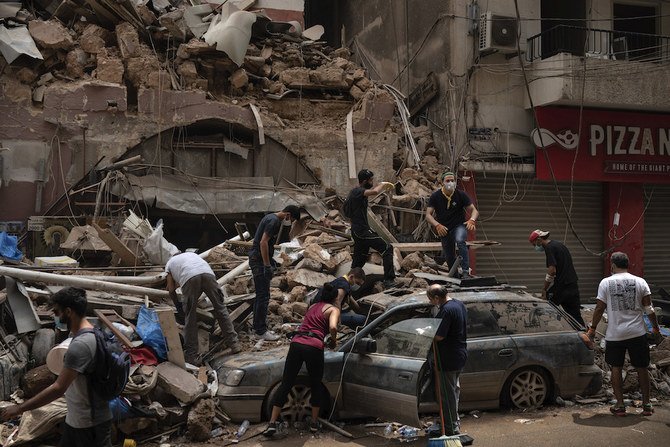 2020年8月7日、レバノン、ベイルートの湾港地区で、4日の爆発により被害を受けた家屋から、人々が瓦礫を取り除いている。大規模爆発がレバノンの首都で建物を次々と破壊した後、レスキューチームは7日、遺体を求めてベイルートの湾港地区の倒壊家屋をまだ捜索している。（AP通信）