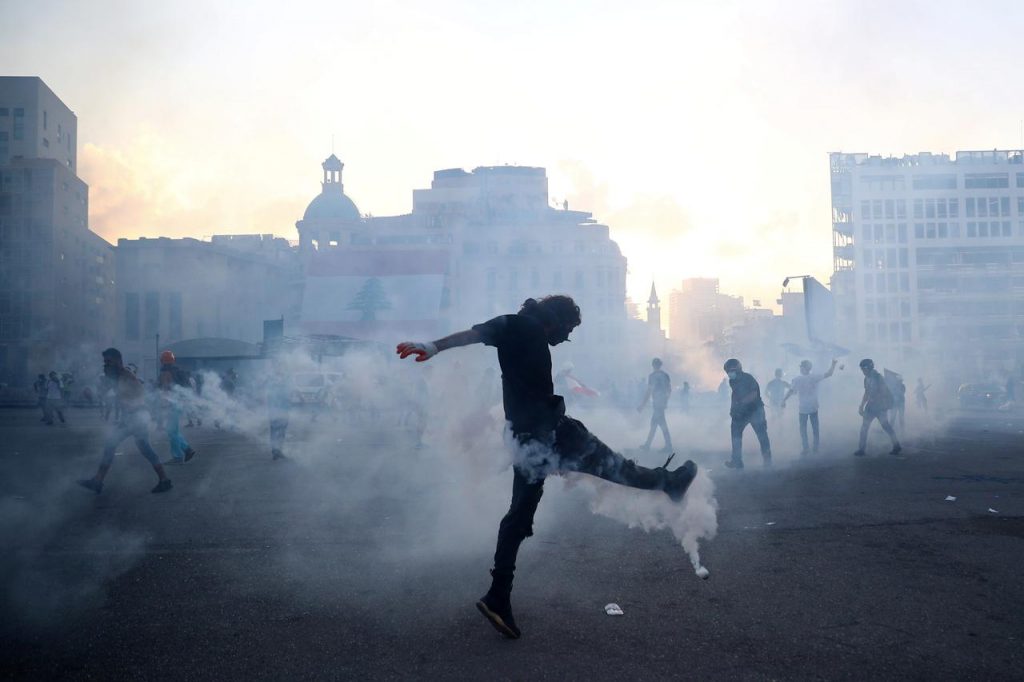 抗議行動中に機動隊が発砲した催涙ガス容器を蹴るデモ参加者＝２０２０年８月８日、レバノン・ベイルート （ロイター通信)