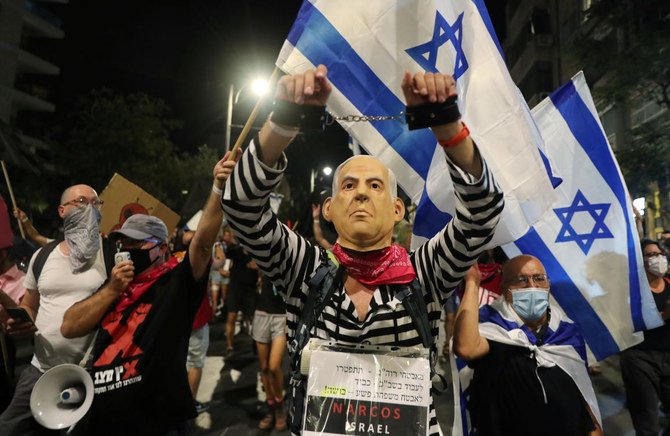 イスラエルのベンヤミン・ネタニヤフ首相を描いたマスクをつけた抗議者が、同首相の汚職疑惑とコロナウイルス感染症(COVID-19)危機の間のロックダウンに起因する経済的苦難に抗議するデモに参加している。2020年8月29日エルサレム、首相公邸近くにて。(ロイター通信/Ammar Awad)