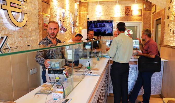 イラク北部クルディスタン地域のスレイマニヤにある両替所で順番を待つイラク市民。 （AFP）