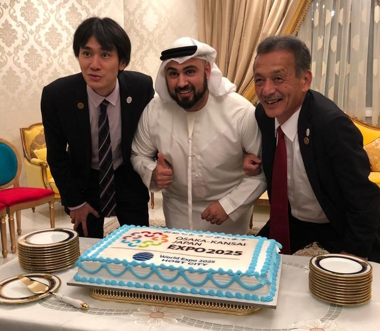 大阪万博の勝利を祝い、日本の委員長（右側）および副委員長（左側）と一緒に写真を撮るサウード・アル・ヌーリ氏。（提供）