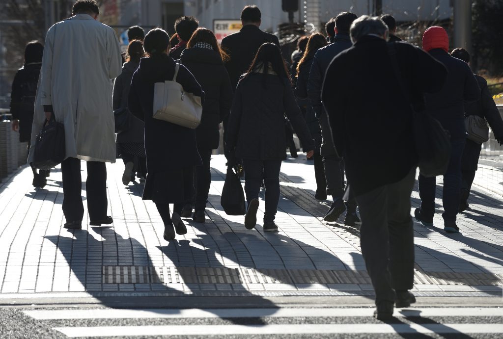朝の東京で仕事に行くため通りを歩く人々。2019年2月1日。