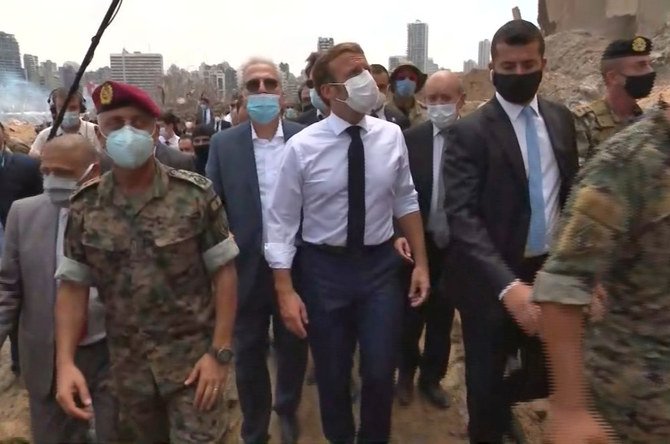2020年8月6日に、レバノンの首都ベイルートの港で、エマニュエル・マクロン仏大統領（写真中央）が被害状況を視察する場面をとらえたスクリーンショット。（合同取材/ AFP）