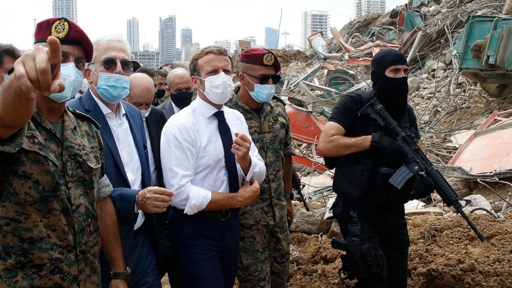 フランスのエマニュエル・マクロン大統領が2020年8月6日、レバノン軍人に護衛され、ベイルート港の爆発現場を訪問。（AFP）