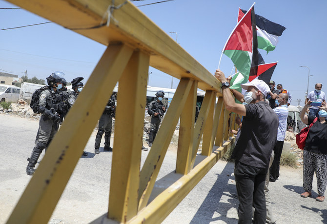 占領下の西岸地区の一部を併合するイスラエルの計画に抗議するパレスチナ人のデモを見守るイスラエルの治安部隊員、ナブルスの南西、パレスチナの村ハリスにて、2020年8月7日（AFP）
