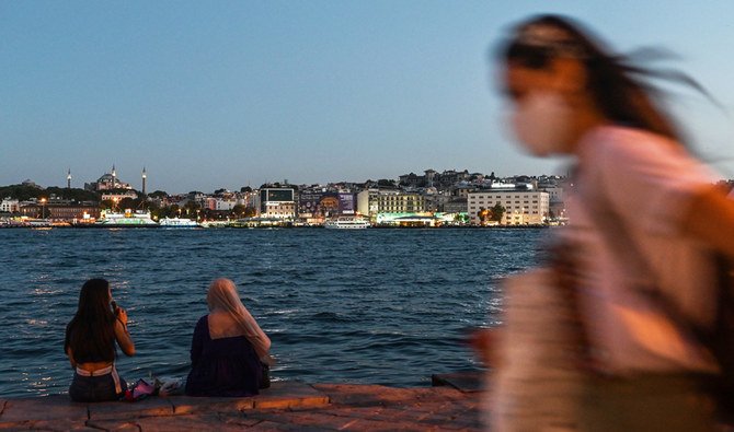 2020年8月3日、イスタンブールのカラコイ地区で、アヤソフィアを背景にボスポラス海峡のほとりでおしゃべりする2人の女性。（AFP）