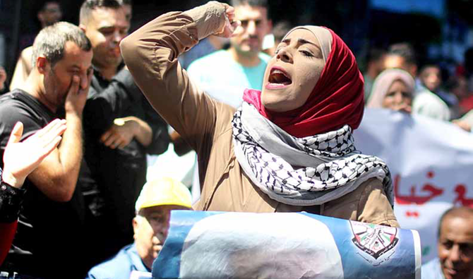 19日、ガザ市で、UAEのイスラエルとの国交正常化交渉への抗議中にスローガンを叫ぶパレスチナ人女性。（ロイター）