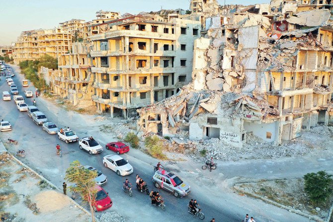 日曜日、シリア新政権による、過激派が支配する地域への攻撃が懸念される中、イドリブの住宅地を走る、結婚式の車列。(AFP)