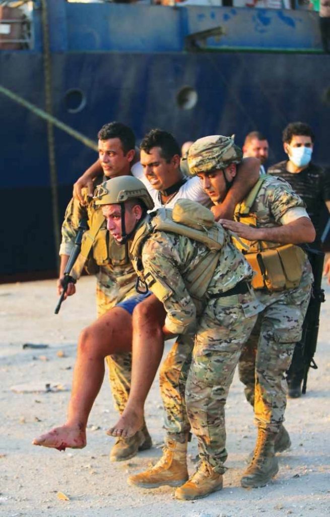 2回の爆発後、レバノン軍兵士が負傷者を安全な場所に運ぶ。 ベイルートの知事は涙を流しながら、首都を「荒廃した街」と表現した（AFP）