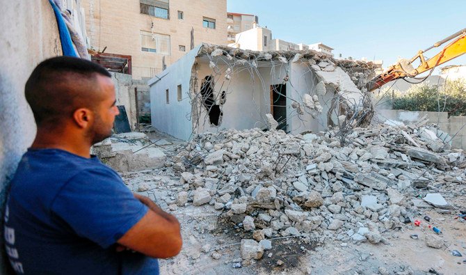 東エルサレムのアル＝トゥールで、パレスチナ人のシャラルダ家の親戚が、掘削機が自宅を解体するところを眺める。イスラエル当局は国内で定期的に、建設許可を持たないパレスチナ人の家を取り壊している（AFP）