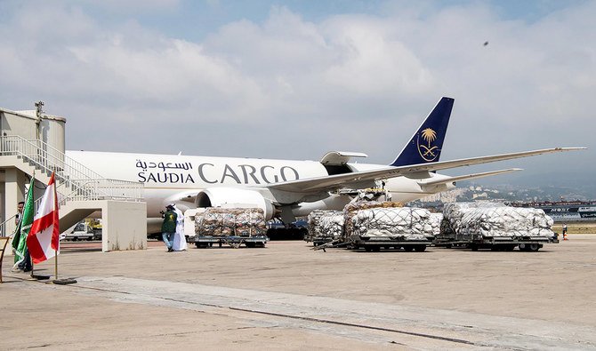 レバノンで4日に起きた爆発の後、支援のためにベイルート国際空港に降ろされた援助物資の隣りに見られる、サルマン国王人道援助救援センターのスタッフ(2020年8月7日撮影)(SPA ロイター経由)。
