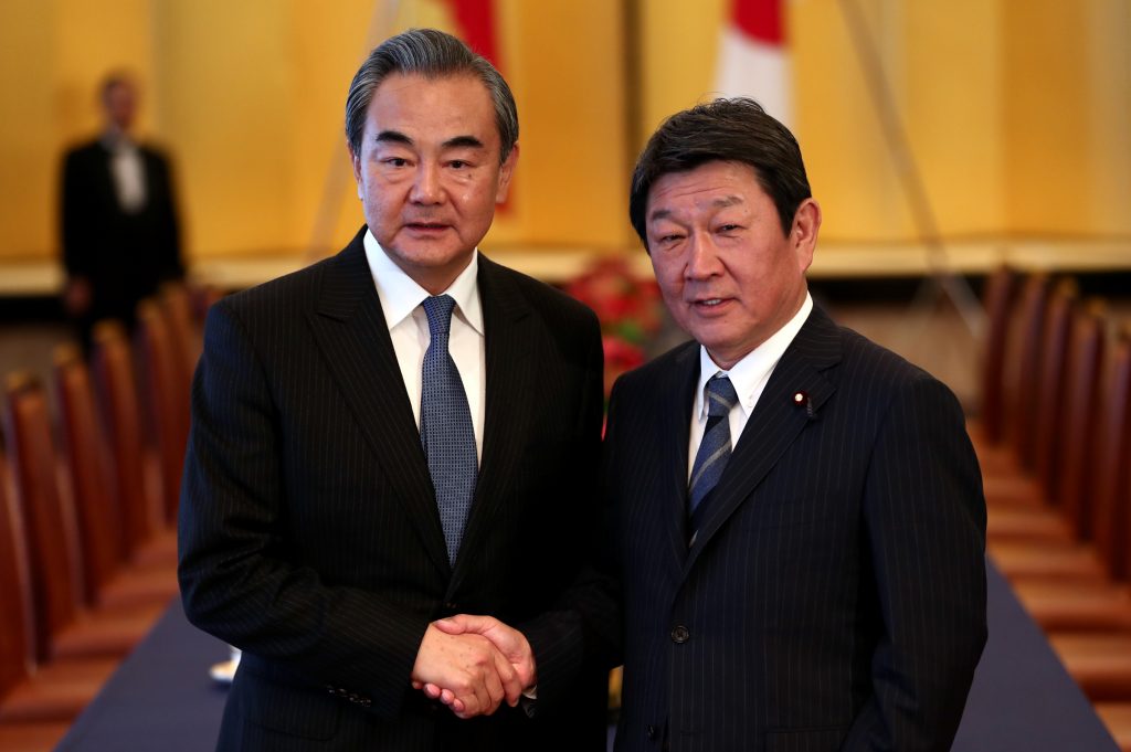 2019年11月25日、東京での会談で中国王毅外相（左）と握手をする日本の茂木敏充外務大臣（右）（AFP）