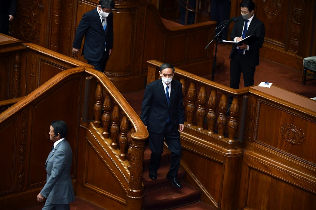 東京の衆議院で新たな首相を選ぶため票を投じた後、その場を離れる新しく選出された日本の自由民主党（自民党）のリーダー菅義偉（右から2人目）、副総理兼財務大臣の麻生太郎（左）、および外務大臣茂木敏充（左から2人目）。（AFP）