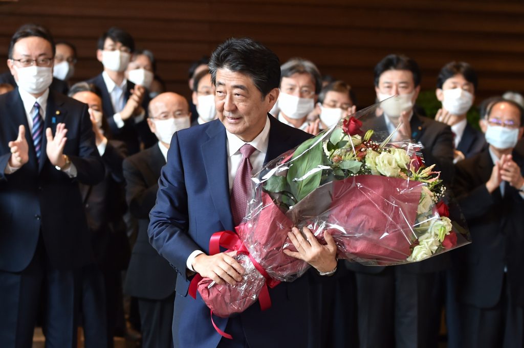 職員から花束を手渡され、首相官邸を出る安倍晋三首相=16日午後、東京・永田町 (AFP)