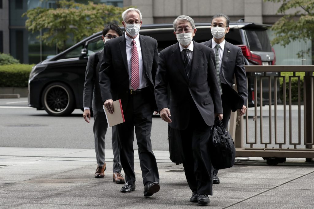 グレッグ・ケリー元日産代表取締役（正面左）が、初公判のために、2020年9月15日審理が行われる東京の東京地方裁判所に到着。ケリー被告の会計上の不正行為を問う裁判は、15日に開廷する。日本の検察は、元スター経営者のカルロス・ゴーン被告に報酬を支払うための複雑で、秘密の計略があった、と自らが主張する起訴内容を述べた。（AP通信）