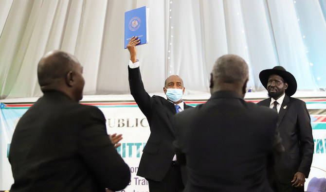スーダン最高評議会議長のアブドルファタハ・アルブルハン将軍が（隣にいるのは南スーダンのサルバ・キール・マヤルディ大統領）スーダンの5つの主要反政府勢力と交わした和平合意書を掲げる様子。オマル・バシル大統領統治下で激化した根深い紛争を解決するための重要な一歩。2020年8月31日、南スーダン首都ジュバ。（ロイター）