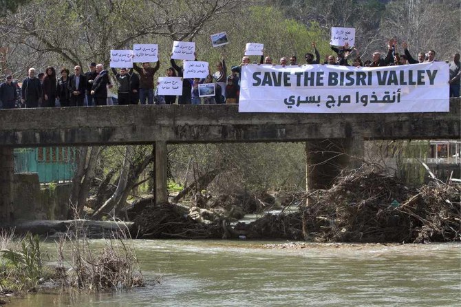 レバノン、ベイルートの南東58キロに位置するビスリ谷のビスリ・ダム計画に反対する抗議行動中にプラカードを掲げるレバノンの抗議者たち（2019年3月10日）。(AP提供写真)