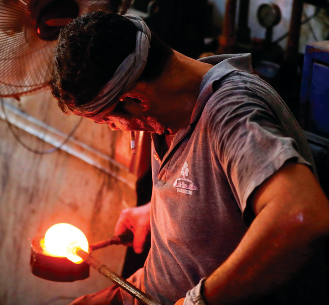 レバノン北部の港町トリポリで、ベイルートの爆発で割れたガラスをリサイクルしている工場の従業員。(AFP)