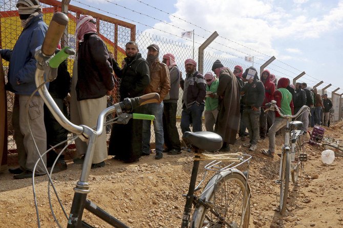 ヨルダンのアンマンから100キロ（62マイル）東にあるアズラク難民キャンプの雇用対策事務所に登録すべく、シリア人難民たちが列をなす。（資料/AP/ラード・アダイレハ）