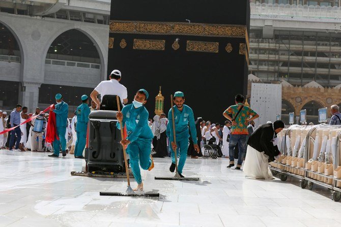 サウジアラビアのメッカ市にある大モスクのカアバの床を掃除する、保護マスクを着用した清掃員たち。（資料写真/ロイター）