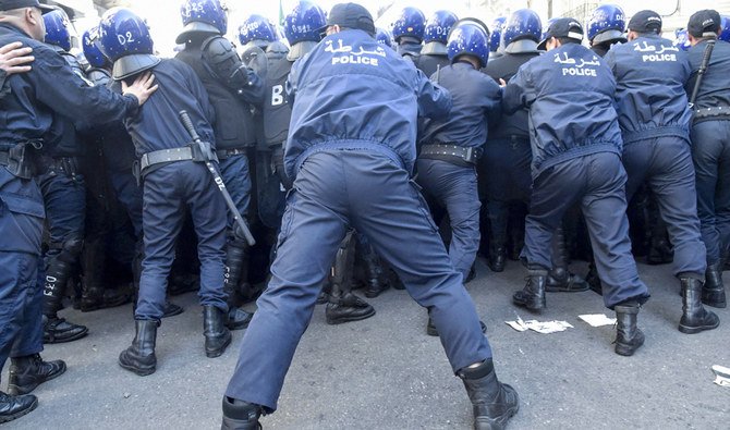 首都アルジェにて2020年2月22日、大統領府に向かう反政府デモ隊を制止するアルジェリア警察。（AFP）