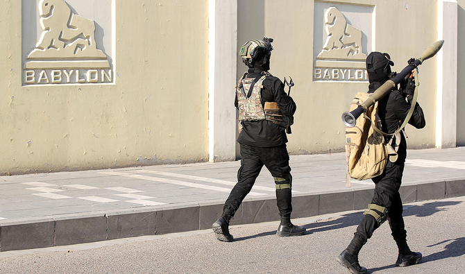 バグダッドの街を練り歩く人民動員隊員ら。同隊は、イランに近く、米国の動きに目を光らせる諸グループが牛耳っている。（AFP）