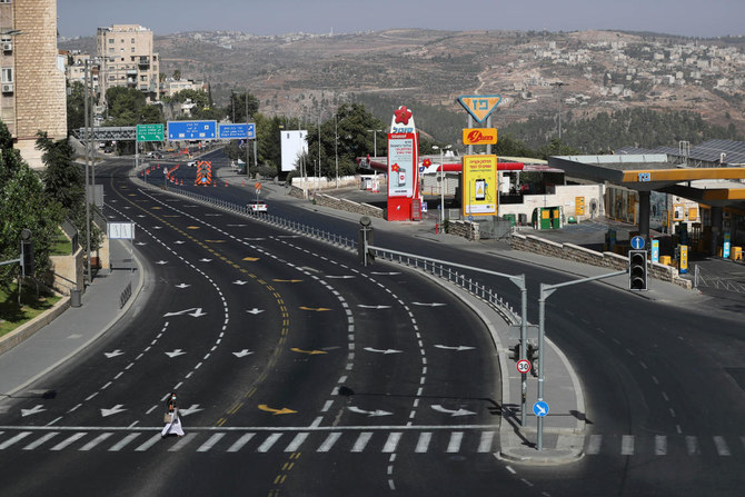 イスラエルが新型コロナウイルスの感染拡大を受け、2度目の全国的ロックダウンを実施する中、2020年9月28日エルサレムで、ユダヤ教の1年で最も神聖な贖罪の日、ヨム・キプルの祭日に人気のない横断歩道を渡る女性。（Reuters）
