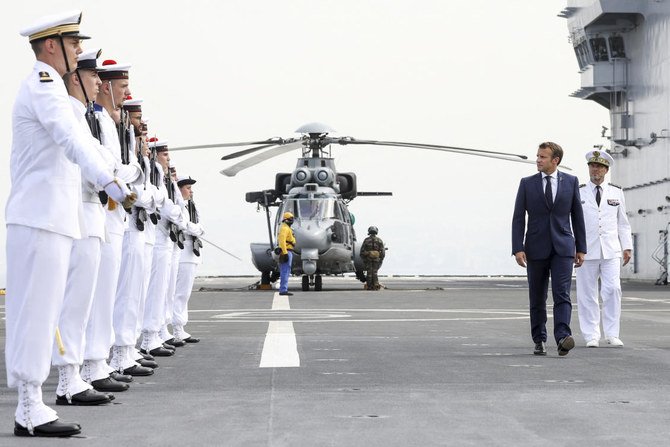 2020年9月1日火曜日、ベイルート港沖のフランス軍のヘリ空母「トネル」に到着して部隊を閲兵するエマニュエル・マクロン仏大統領。ベイルートへの訪問は、壊滅的な8月4日の爆発事故以来、2回目の訪問である。この事故はレバノンの歴史の中で最も被害の大きな単一の事故であり、少なくとも190人が死亡した（AP）