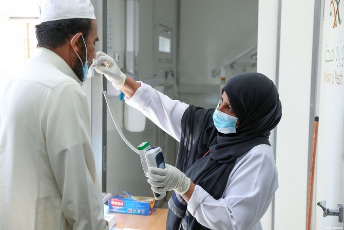 サウジアラビアの看護師が、聖地メッカのアジャド・アルマサフィ地区の住民のための移動クリニックで患者の体温をチェックする。 （AFP /ファイル）