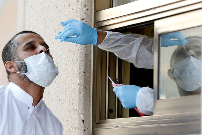 バーレーンへ渡航したサウジ国民が、新型コロナウイルス感染症（COVID-19）の制限が緩和された後再開されたキング・ファハド・コーズウェイの入国検問所で、鼻腔スワブ検査を受けている。バーレーンとサウジの国境にて。バーレーン、2020年9月15日。（ロイター）