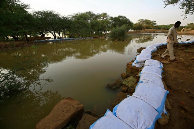 首都から北へ300Kmのナイル川州アル=バジャウィア地区のメロエ遺跡で、古代王都の建造物への洪水被害を緩和するために、スーダンの古代遺跡当局の作業員が土嚢で石垣を並べている=2020年9月9日 (AFP)