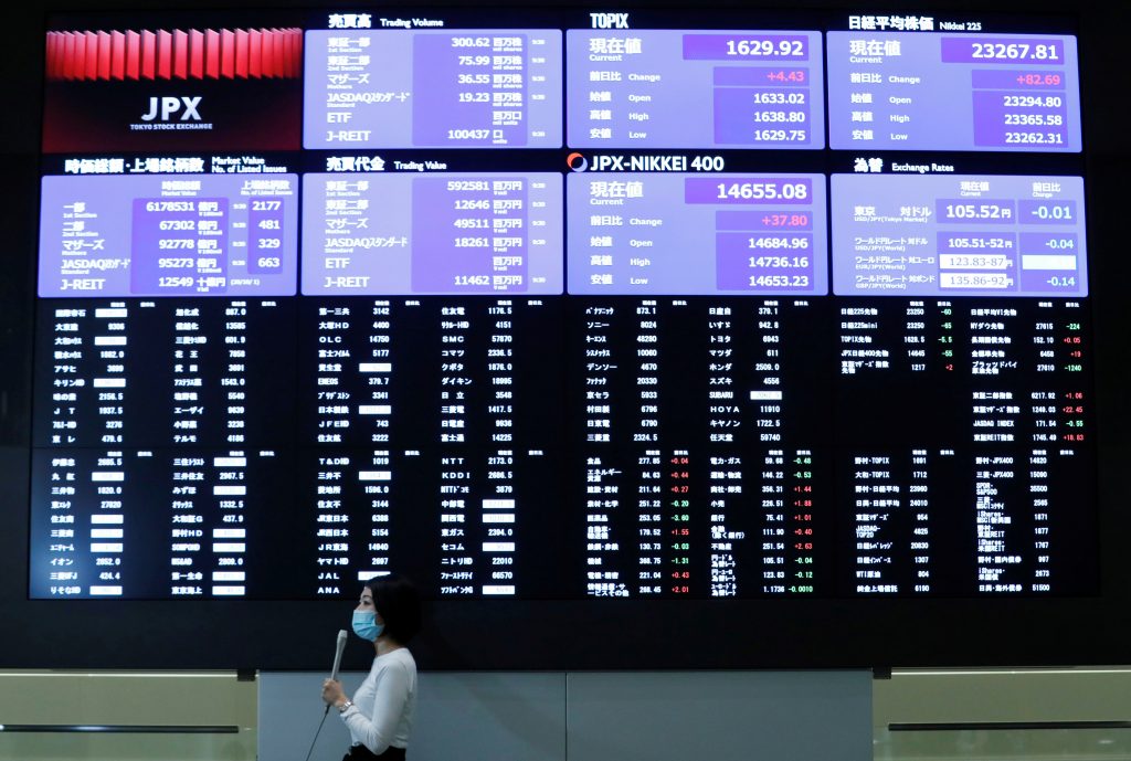 東京で市場が開いた後、東京証券取引所の株価を表示する大型スクリーンの前に立つTVレポーター。2020年10月2日。（資料写真/ロイター）