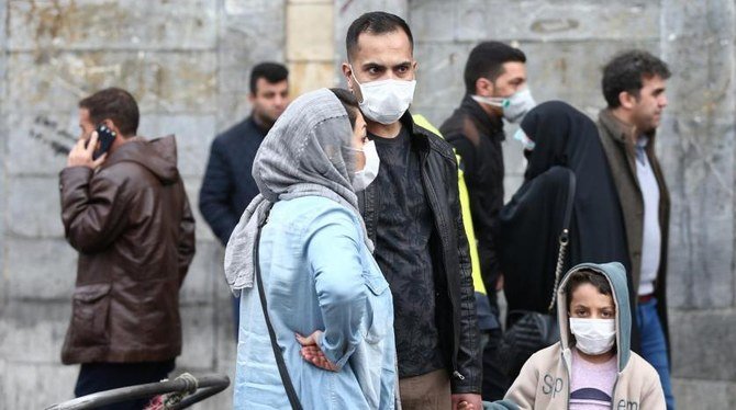 2020年2月20日、イランのテヘランのグランドバザールに立ち、新型コロナウイルスへの感染を防ぐために防護マスクを着用しているイラン人家族。（ロイター）