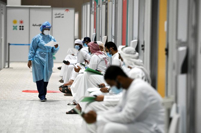 2020年10月6日、アラブ首長国連邦アブダビのアブダビ国立展示場に座る、ワクチン試験の順番を待つ人々。2020年10月6日撮影。(ロイター)