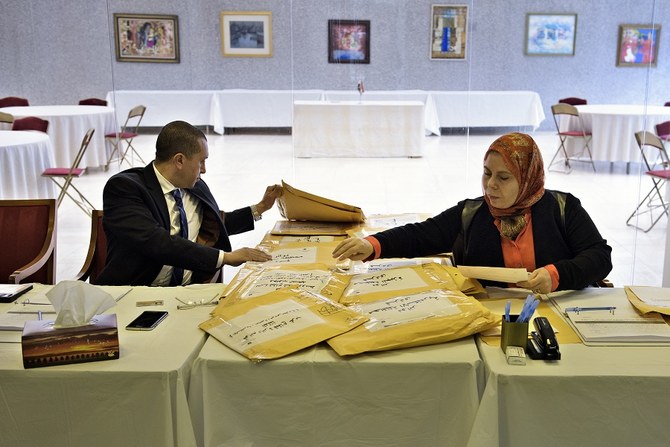 2015年10月18日にワシントンDCのエジプト大使館で行われたエジプト議会選挙の投票中、市民に提供する投票用紙を整理する大使館職員。（資料写真/AFP）