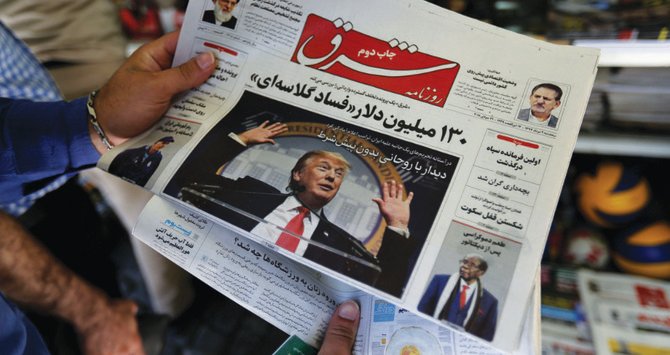 1面にドナルド・トランプ米大統領の写真が掲載された新聞を眺めるイラン人。アメリカの大統領選挙の結果に対するイラン国民の関心は国内で急上昇している。（AFP）