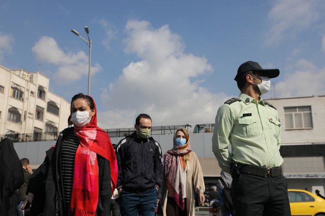 新型コロナウイルス感染症の大流行で、イラン当局が公共の場所でのマスク着用を義務化したことを受け、マスクを着けて路上を歩く住民。（ウエスト・アジア・ニュース・エージェンシー、ロイター経由）