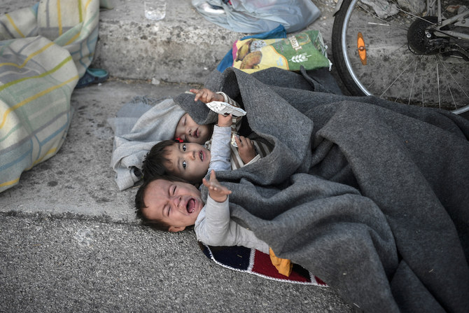 2020年9月10日未明、レスボス島にあるギリシャ最大のモリア難民キャンプが火災で焼失した後、ミティレネ近くの道路で一夜を過ごした子供たちが目を覚ます（AFP）